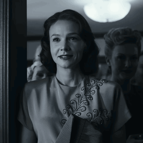 A Black And White Photo Of A Woman Wearing A White Top GIF