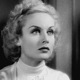 A Black And White Photo Of A Woman Wearing A White Turtleneck And A Bow Tie . GIF