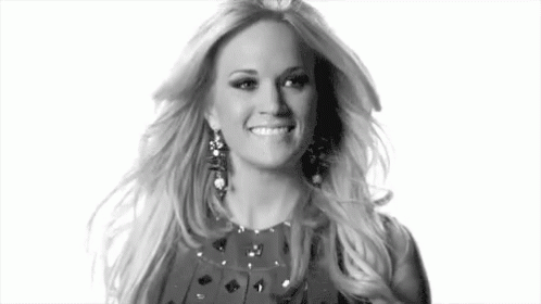 A Black And White Photo Of A Woman Wearing Earrings And A Dress . GIF