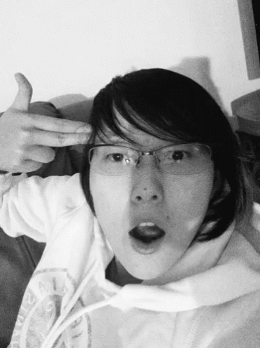 A Black And White Photo Of A Woman Wearing Glasses And A Hoodie GIF