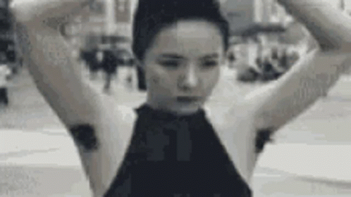 A Black And White Photo Of A Woman With A Bun On Her Head And A Bunch Of Hair On Her Armpits . GIF