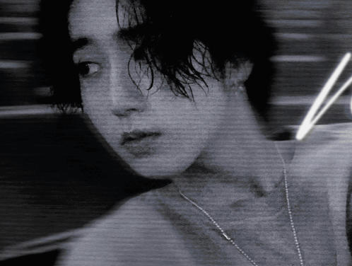 A Black And White Photo Of A Woman With A Necklace Around Her Neck GIF