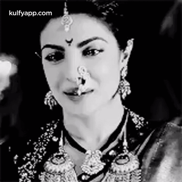 A Black And White Photo Of A Woman With A Nose Ring On Her Nose . GIF