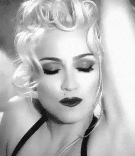 A Black And White Photo Of A Woman With Blonde Hair And A Black Dress . GIF