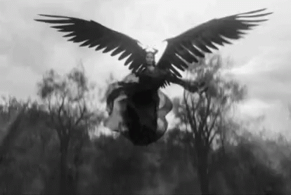 A Black And White Photo Of A Woman With Large Wings Flying In The Air . GIF