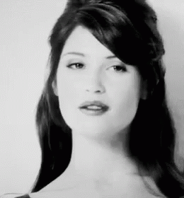 A Black And White Photo Of A Woman With Long Hair And A Fringe . GIF
