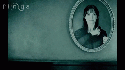 A Black And White Photo Of A Woman With The Word Rings Written On The Wall GIF
