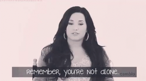 A Black And White Photo Of A Woman With The Words " Remember You 'Re Not Alone " Below Her GIF
