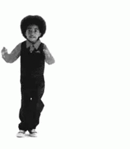 A Black And White Photo Of A Young Boy In Overalls Dancing . GIF