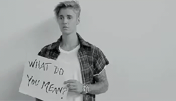 A Black And White Photo Of A Young Man Holding A Sign That Says `` What Do You Mean '' . GIF