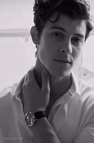A Black And White Photo Of A Young Man In A White Shirt And A Watch . GIF