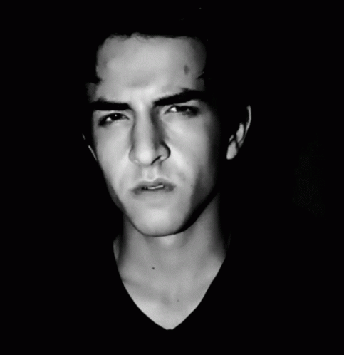 A Black And White Photo Of A Young Man Making A Face GIF