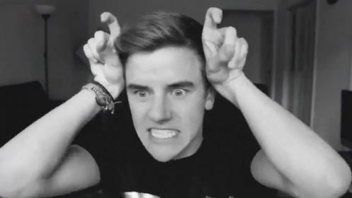 A Black And White Photo Of A Young Man Making A Face GIF
