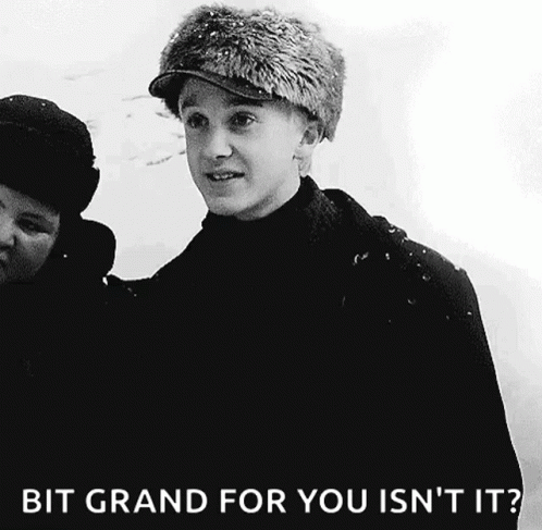 A Black And White Photo Of A Young Man Wearing A Fur Hat With The Caption Bit Grand For You Isn 'T It . GIF