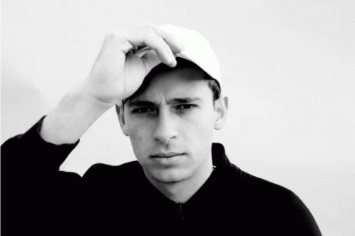 A Black And White Photo Of A Young Man Wearing A Hat GIF