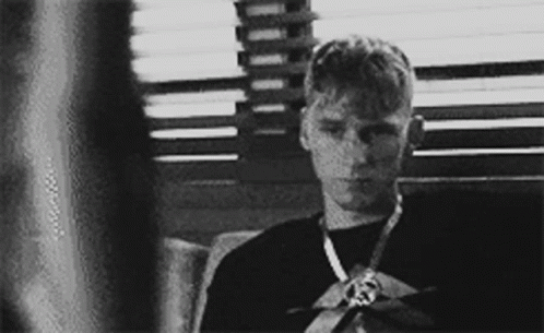 A Black And White Photo Of A Young Man Wearing A Medal GIF