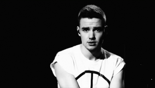 A Black And White Photo Of A Young Man Wearing A Peace Sign Shirt GIF