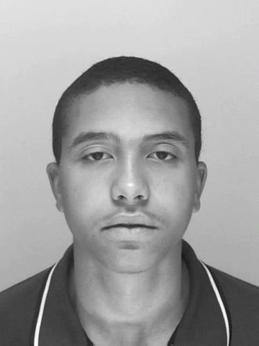 A Black And White Photo Of A Young Man With A Shaved Head GIF