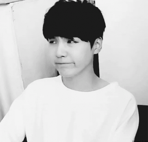 A Black And White Photo Of A Young Man With A White Shirt On GIF