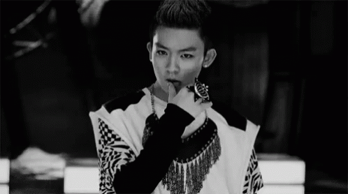 A Black And White Photo Of A Young Man With His Finger On His Lips . GIF