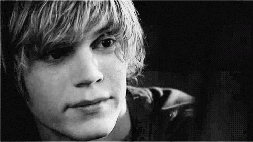 A Black And White Photo Of A Young Man With Long Blonde Hair . GIF