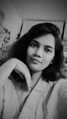 A Black And White Photo Of A Young Woman With Her Hand On Her Chin GIF
