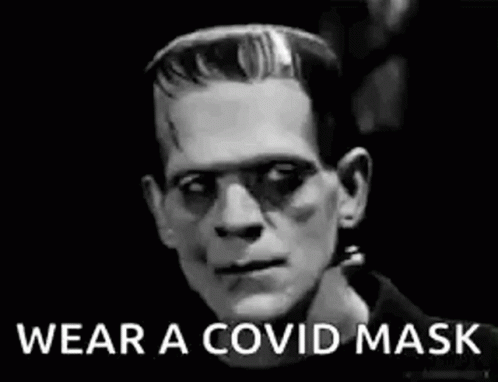 A Black And White Photo Of Frankenstein Wearing A Mask . GIF