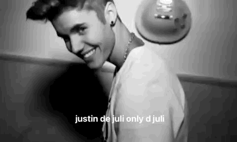 A Black And White Photo Of Justin Bieber Smiling And Looking At The Camera . GIF