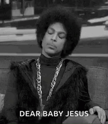 A Black And White Photo Of Prince Sitting On A Couch With His Eyes Closed And A Chain Around His Neck . GIF