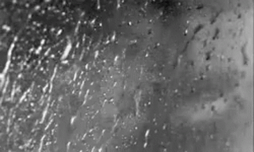 A Black And White Photo Of Rain Drops On A Window GIF
