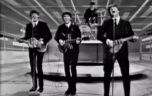 A Black And White Photo Of The Beatles Playing Guitars And Singing Into Microphones . GIF