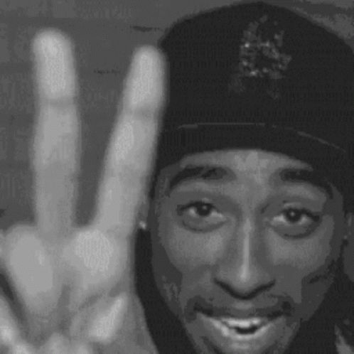 A Black And White Photo Of Tupac Shakur Making A Peace Sign . GIF