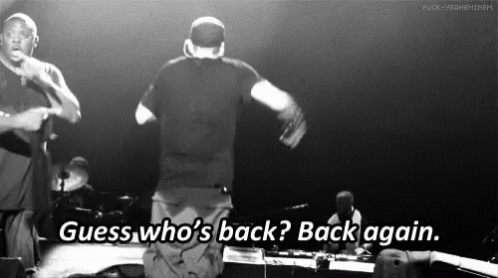 A Black And White Photo Of Two Men On A Stage With The Words Guess Who 'S Back Back Again GIF