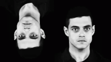 A Black And White Photo Of Two Men 'S Faces One Is Upside Down GIF