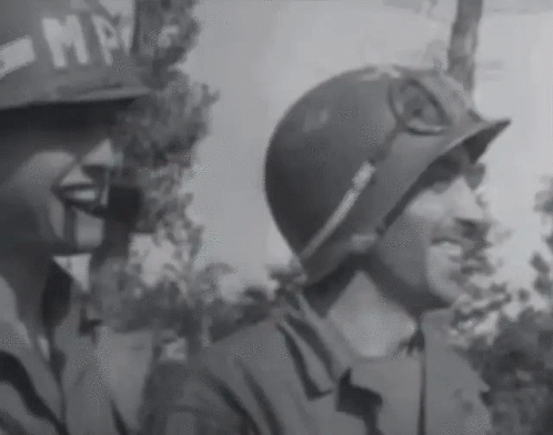 A Black And White Photo Of Two Soldiers With One Wearing A Helmet That Says Mp On It GIF