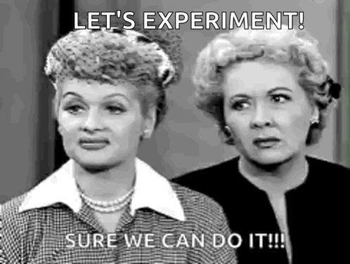 A Black And White Photo Of Two Women Standing Next To Each Other . One Of The Women Is Saying `` Let 'S Experiment ! '' GIF