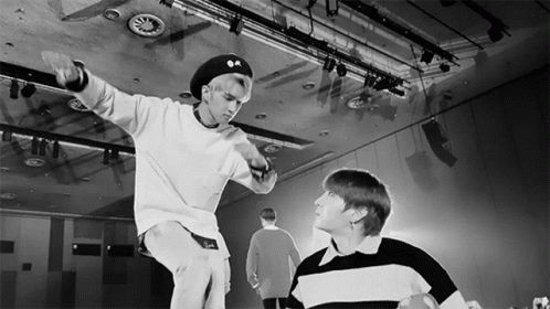 A Black And White Photo Of Two Young Men In A Dance Studio GIF
