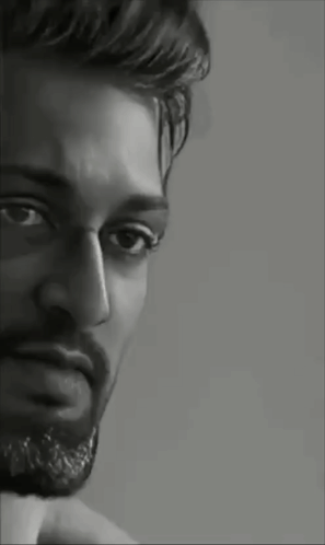 A Black And White Portrait Of A Man With A Beard Looking At The Camera . GIF