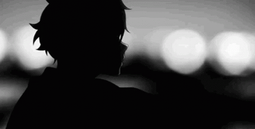 A Black And White Silhouette Of A Person Standing In Front Of A Blurry Background . GIF