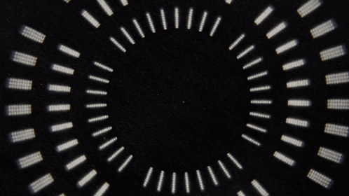 A Black Background With A Circular Pattern Of White Dots GIF