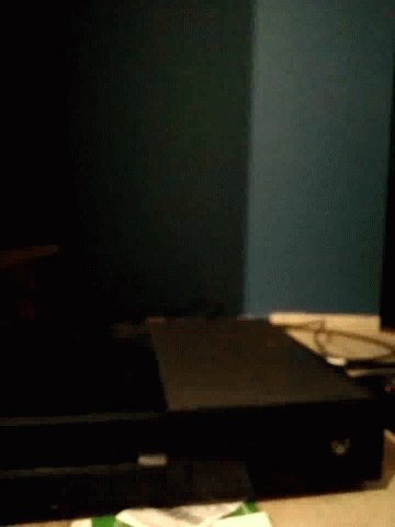 A Black Box Is Sitting On A Table In The Dark . GIF