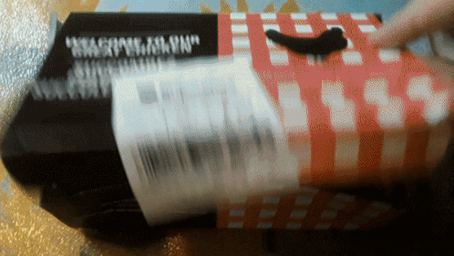 A Black Box With A Red And White Checkered Pattern Has The Word " Weapons " On It GIF