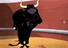 A Black Bull With Horns Is Standing In A Bullring . GIF