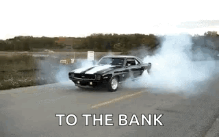 A Black Car Is Drifting Down A Road With Smoke Coming Out Of Its Tires . GIF