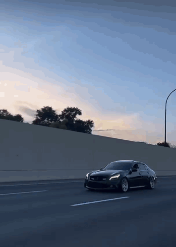 A Black Car Is Driving Down A Highway GIF