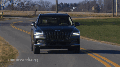 A Black Car Is Driving Down A Road With Motorweek.org Written In The Corner GIF