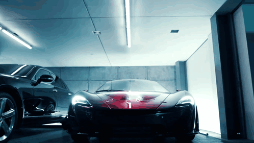 A Black Car Is Parked Next To A Red Sports Car GIF
