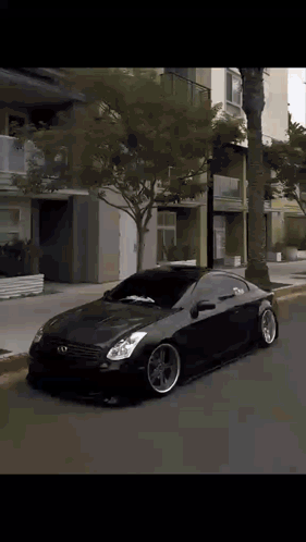 A Black Car Is Parked On The Side Of A Street GIF