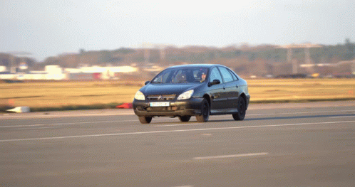 A Black Car With A License Plate That Says ' A ' On It Drives Down A Road GIF