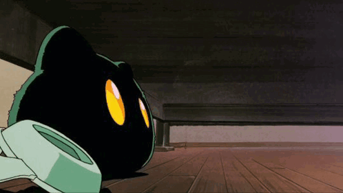 A Black Cat With Yellow Eyes Is Laying Under A Bed GIF